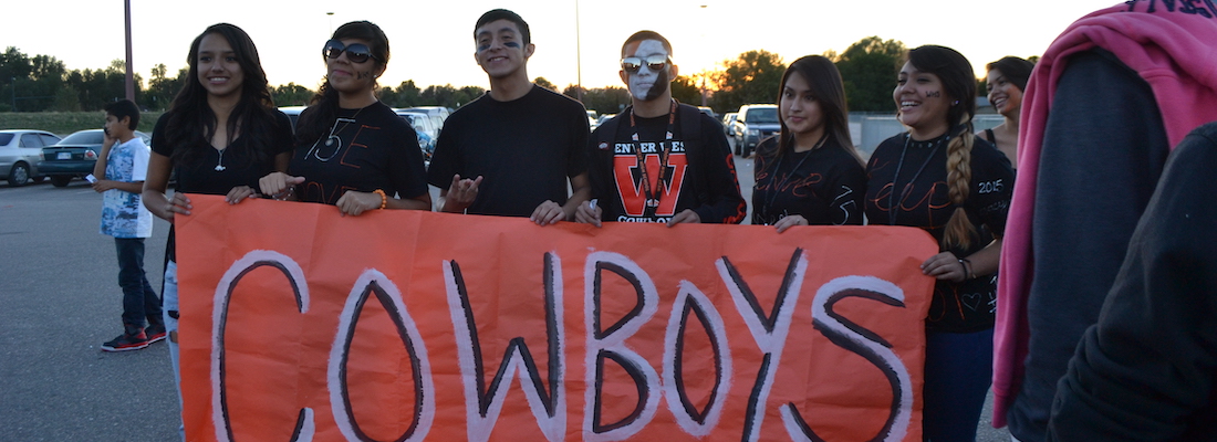 Students holding sign for Cowboys
