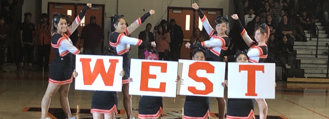 Cheerleaders holding sign for West