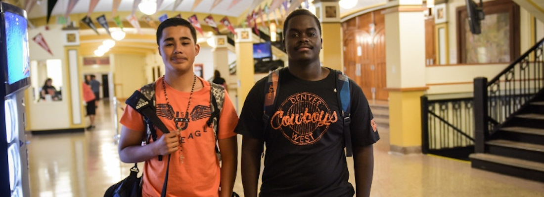 Two students wearing school shirts