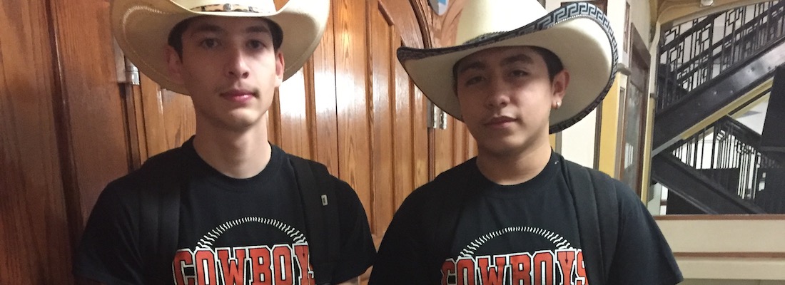 Two students wearing cowboy hats and school shirts